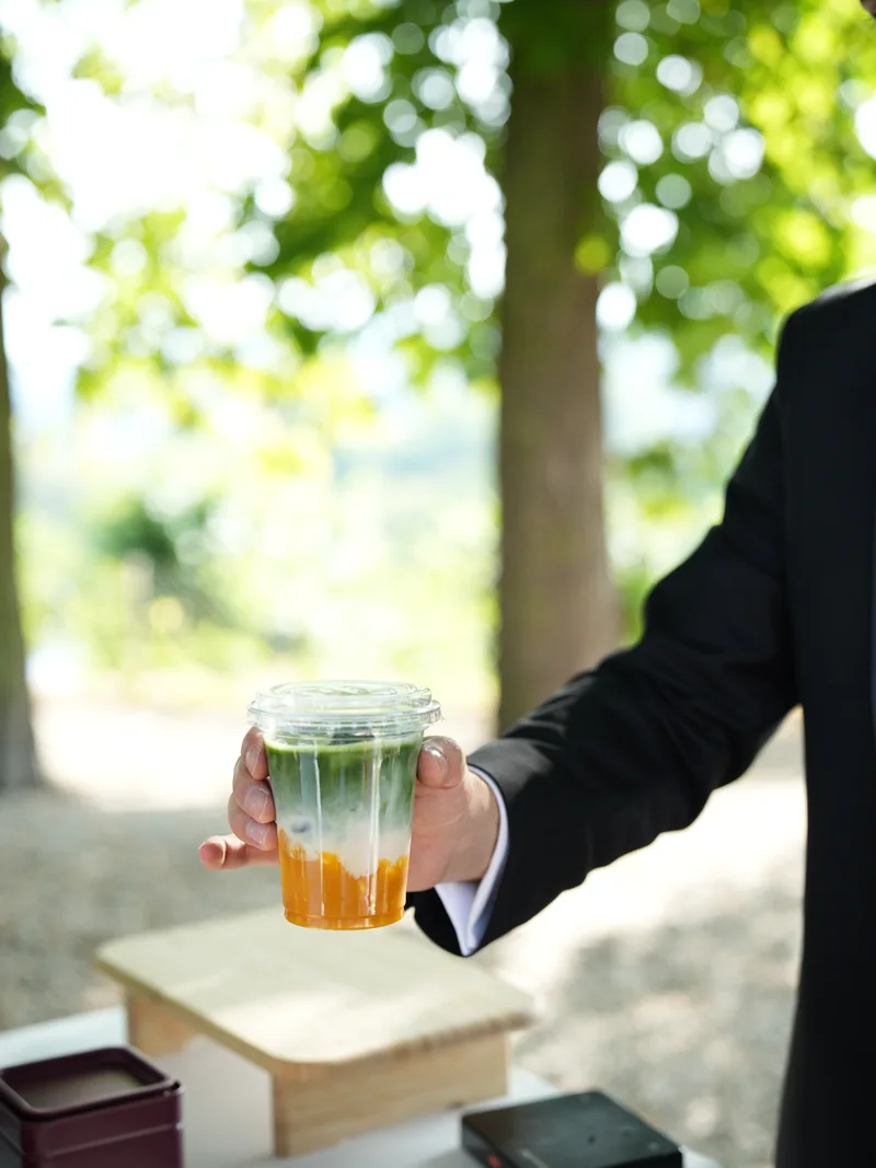 Ein Matcha Drink vor sommerlichem Grün